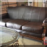 F58. Leather sofa with carved wood arms and feet. 